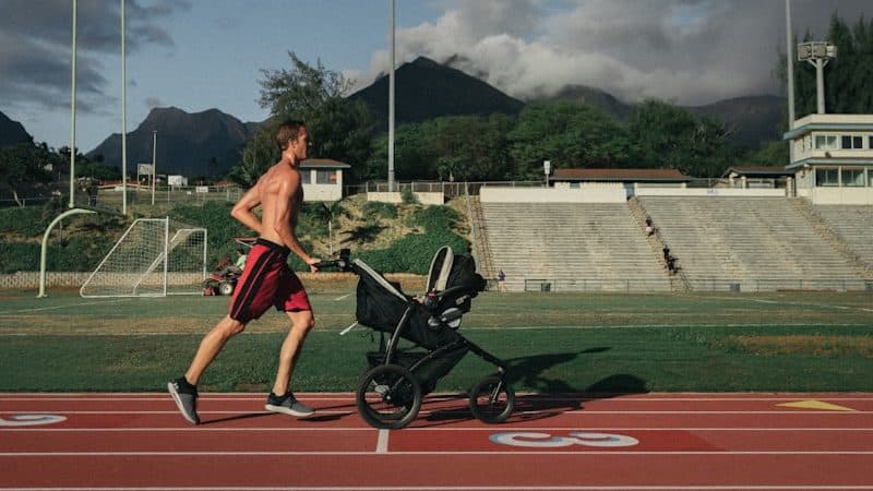 man running while holding stroller
